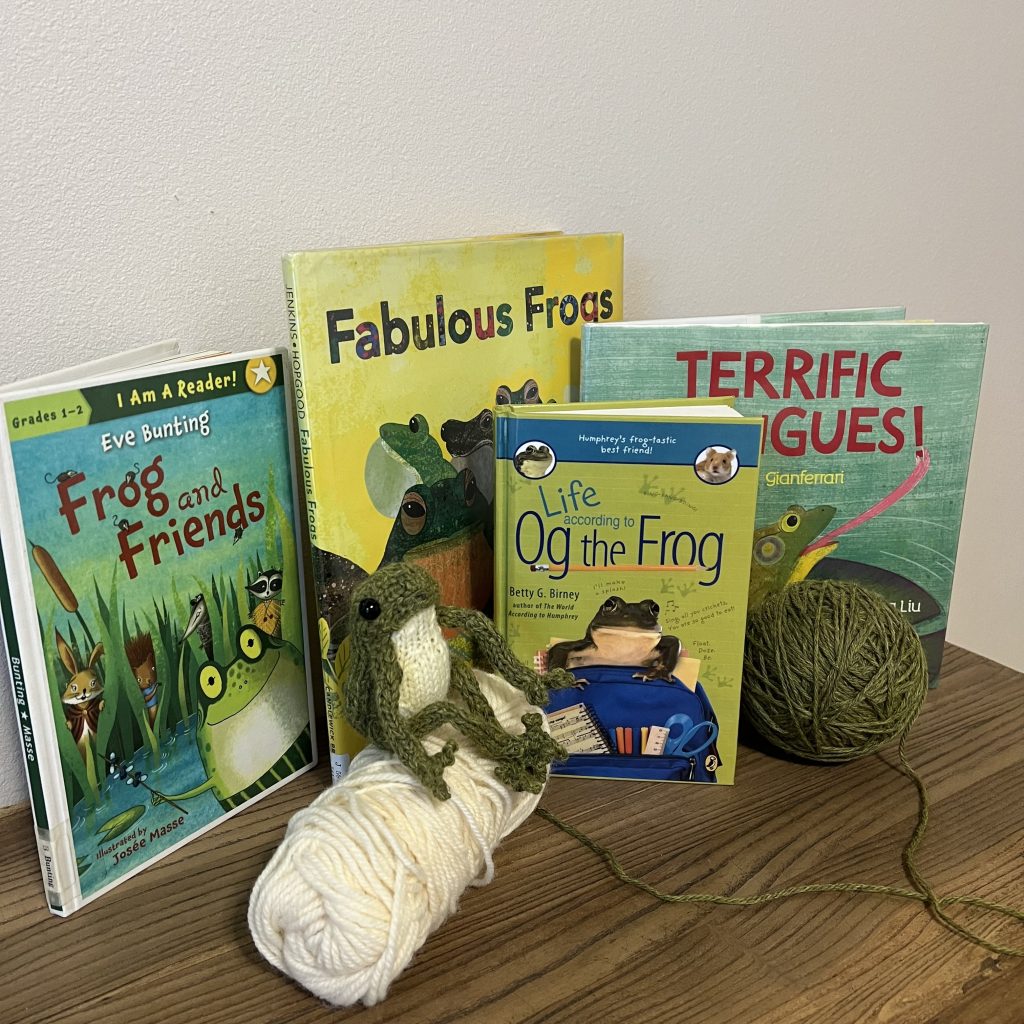 Knit frog made from a pattern by Claire Garland with some of our favorite books about frogs.
